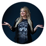 A woman in a black t-shirt is standing in a circle with her arms outstretched.