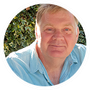 A man in a blue shirt is looking at the camera in a circle.