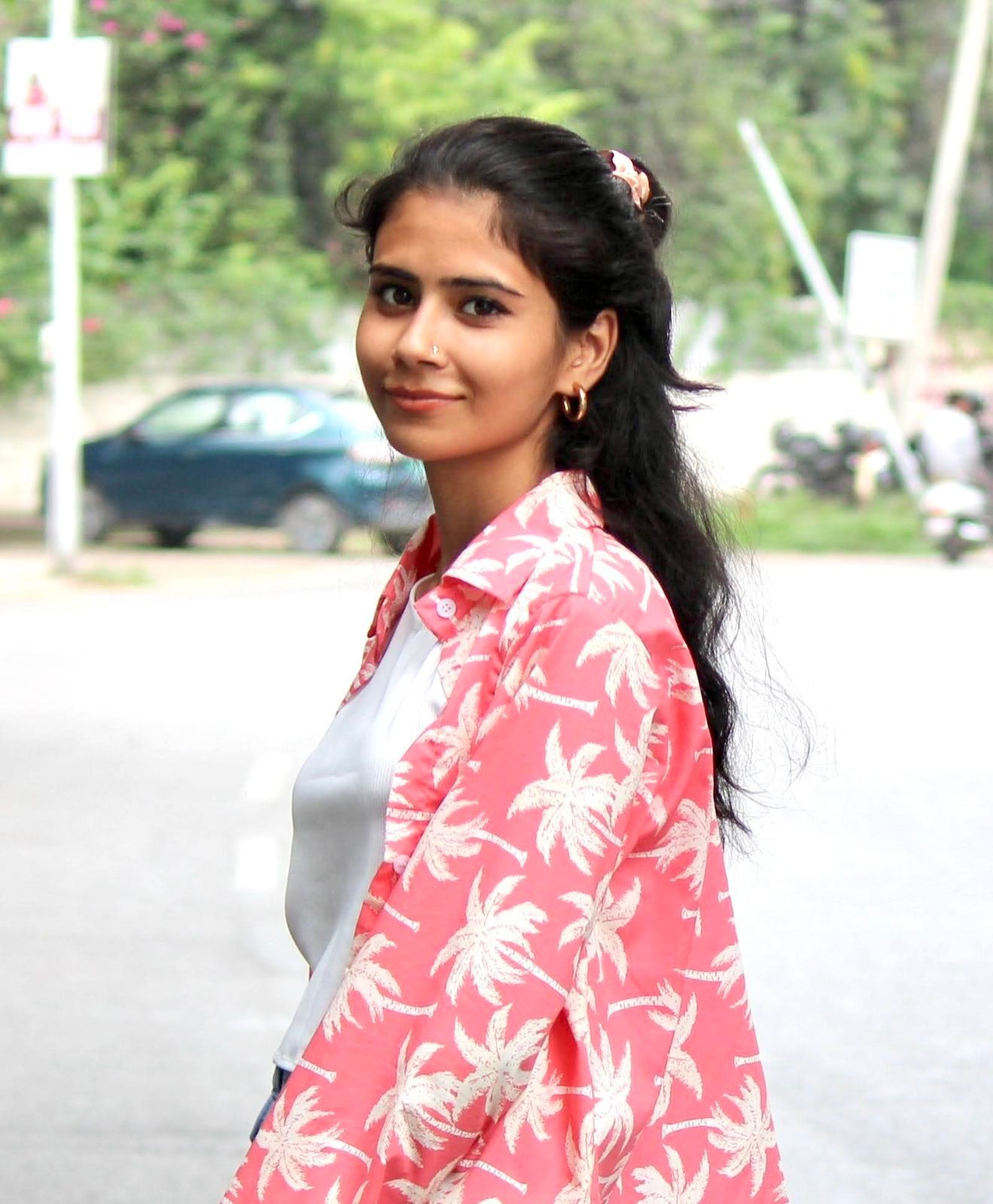 A man is sitting at a table holding a cup of coffee and using a laptop computer.