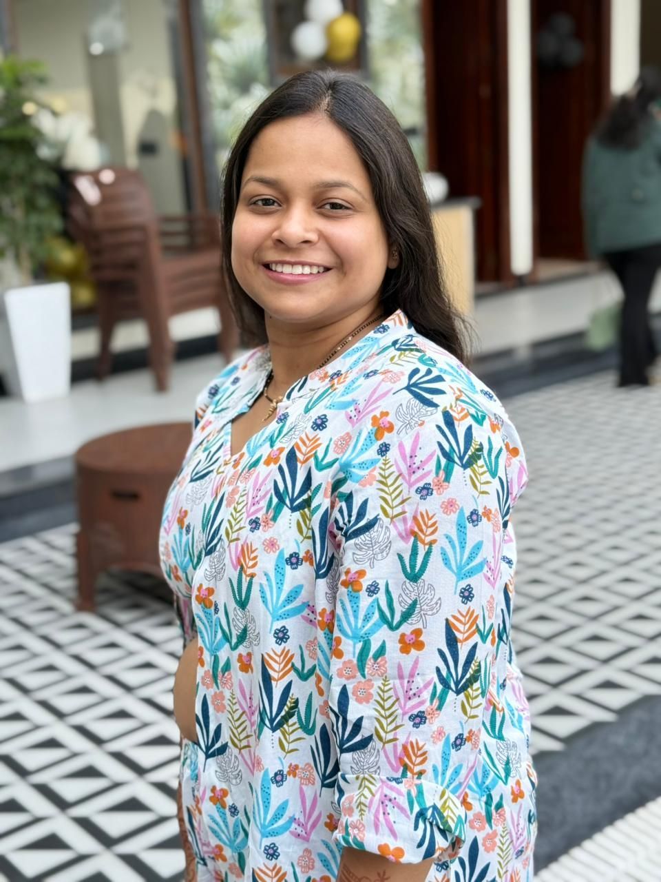 A man is sitting at a table holding a cup of coffee and using a laptop computer.