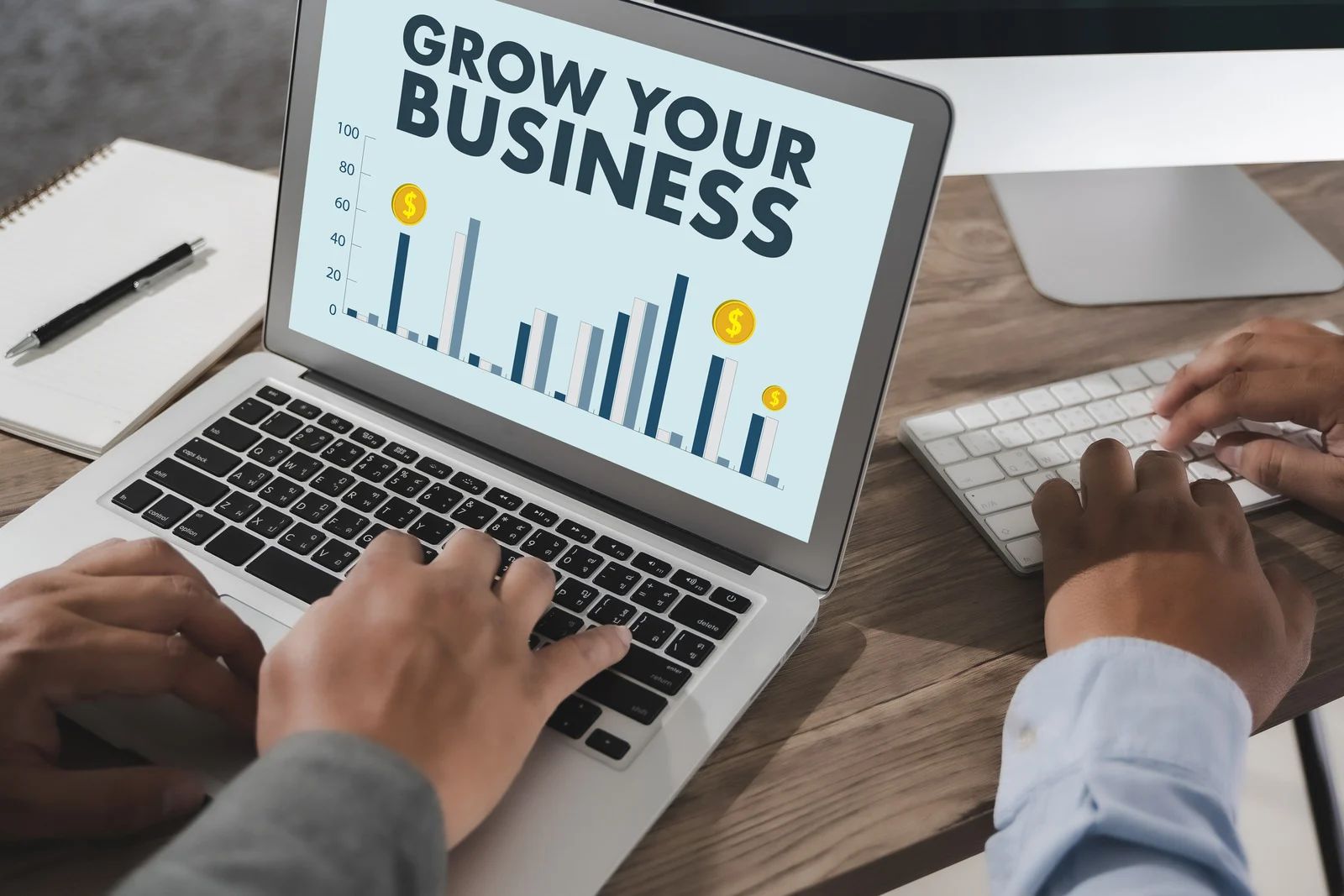 A person is typing on a laptop with the words `` grow your business '' on the screen.