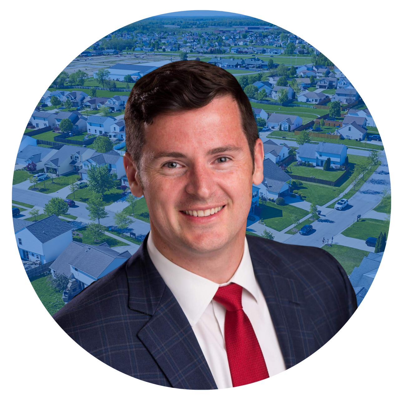 greg pilling in a suit and tie is smiling in front of an aerial view of a residential area