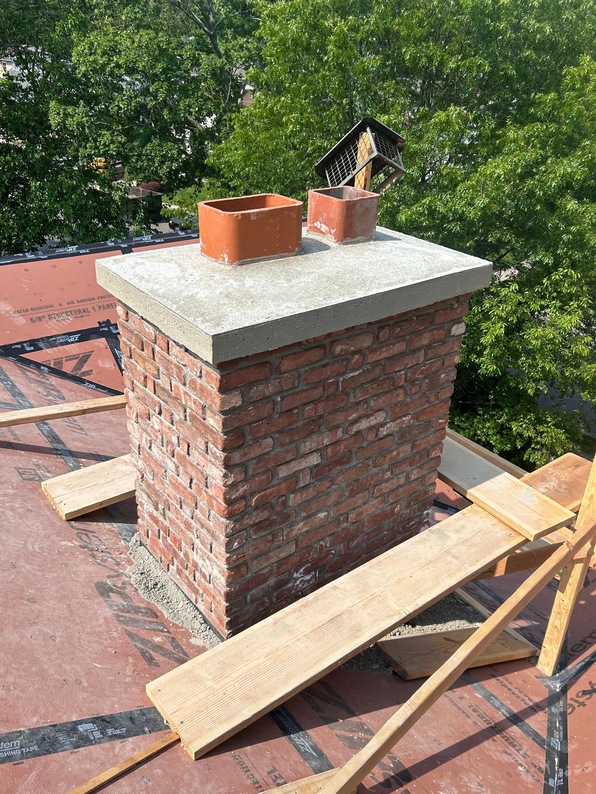 A large excavator is sitting on top of a construction site next to the ocean.