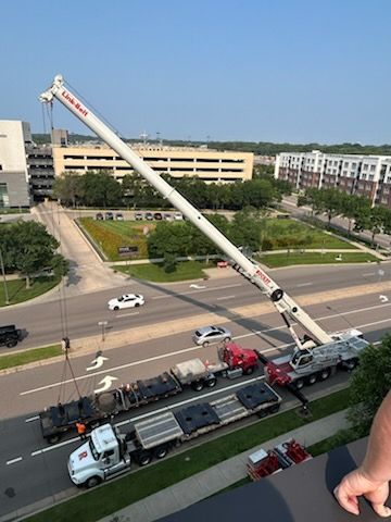 A large crane is lifting a truck on a city street.