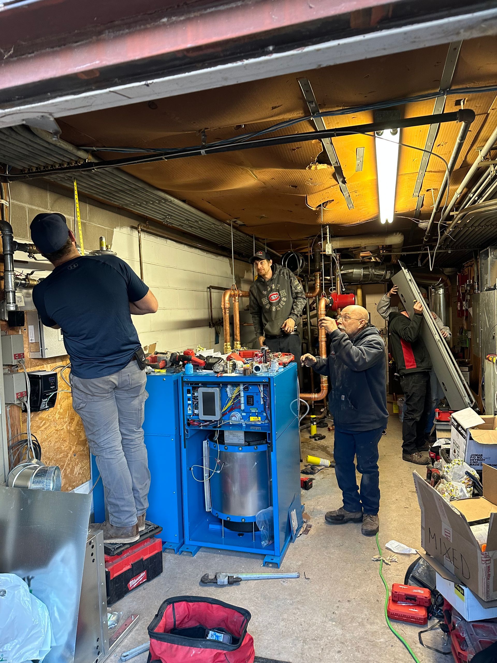 A group of men are working on a machine in a garage.