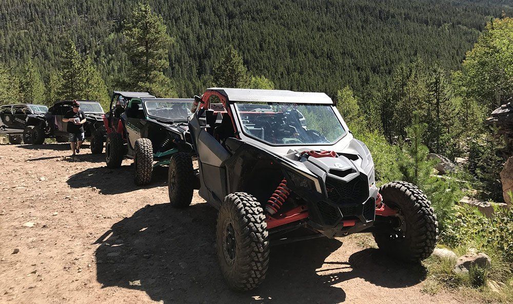 Side by side off road vehicle parked on the edge of a mountain