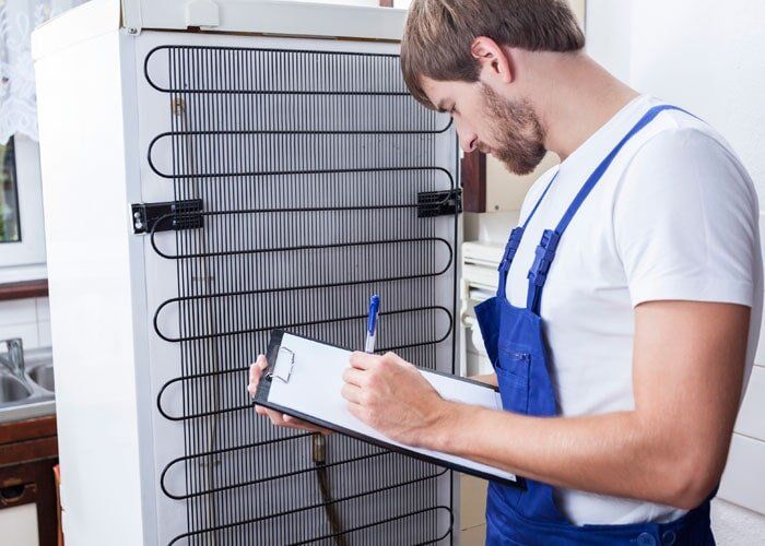 Fumigaciones Juan Control - joven revisando nevera