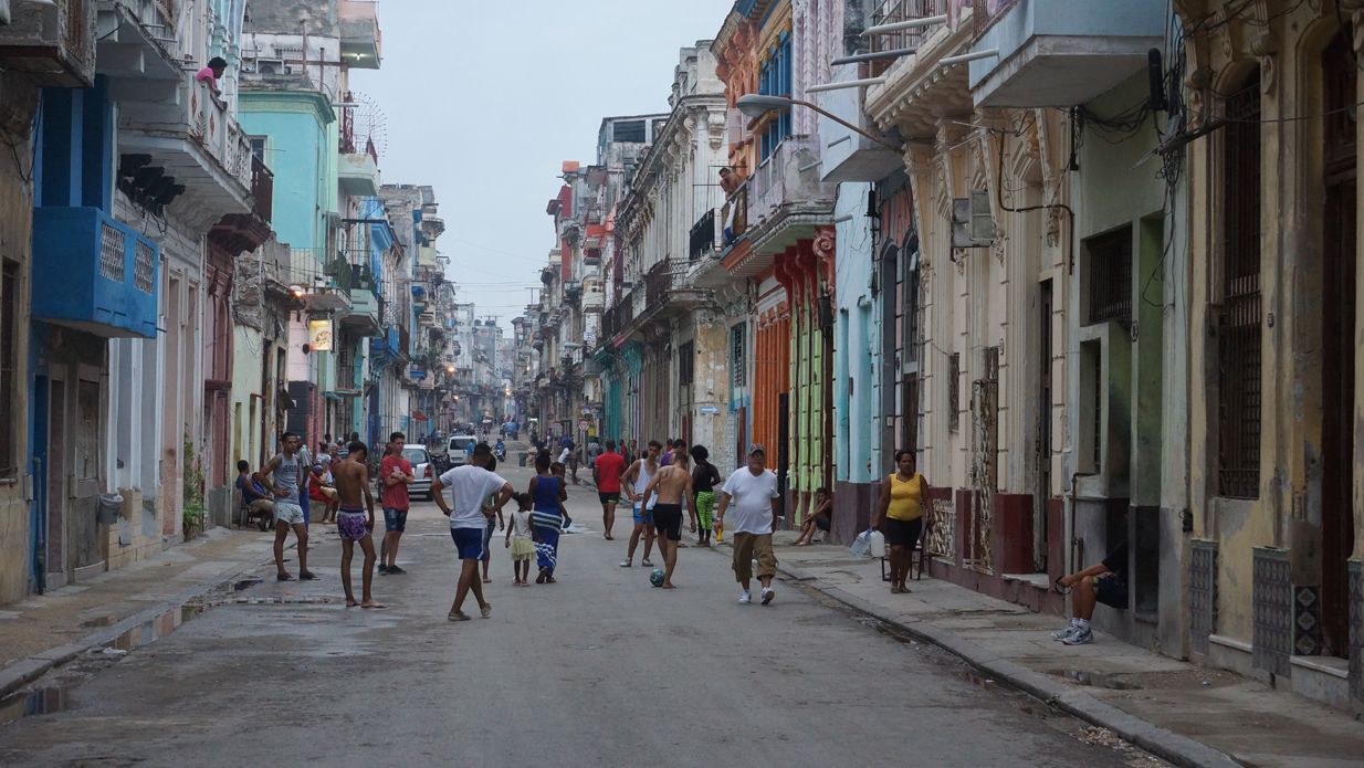 People on a street lined with colorful buildings.