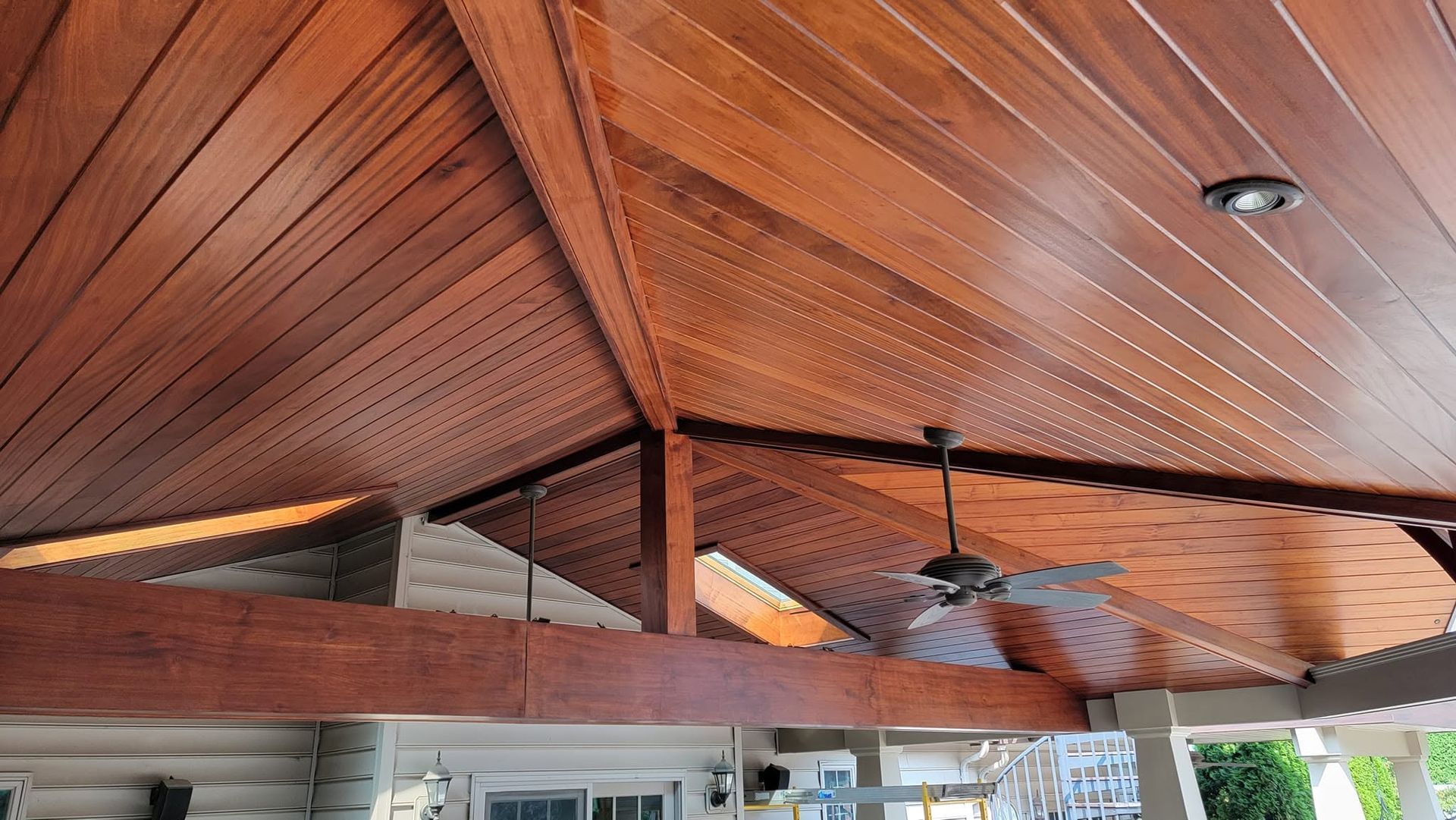 Wood-paneled vaulted ceiling with exposed beams above a rustic interior space