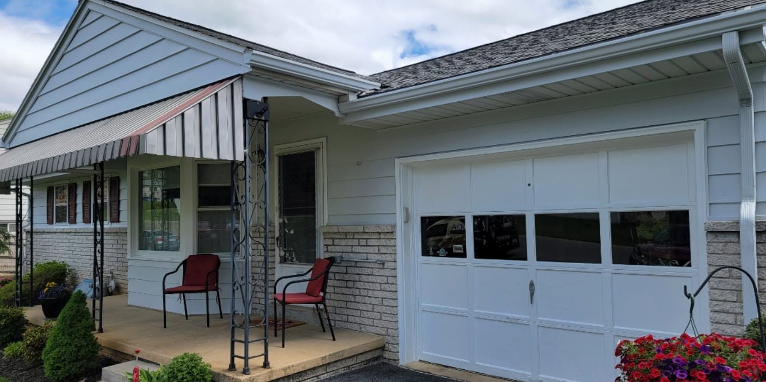 House exterior with front porch, red chairs, and an attached white garage door