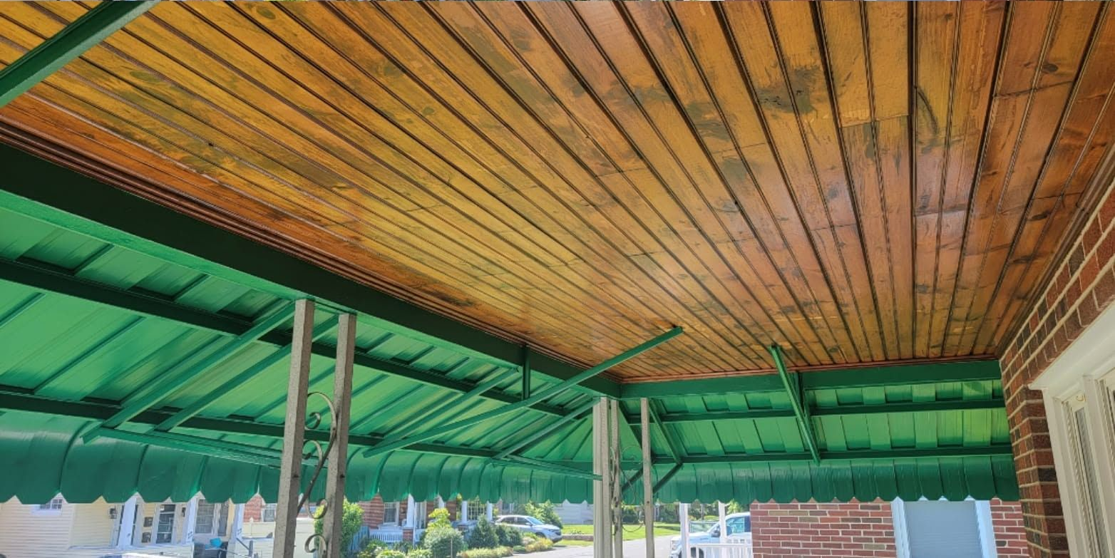 Wooden ceiling with green awnings and a distant view of an outdoor seating area