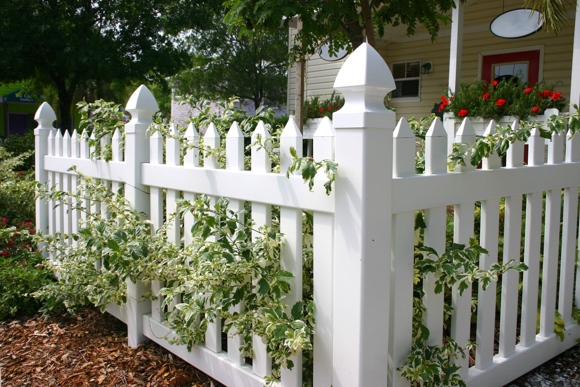 A white picket fence in front of a house