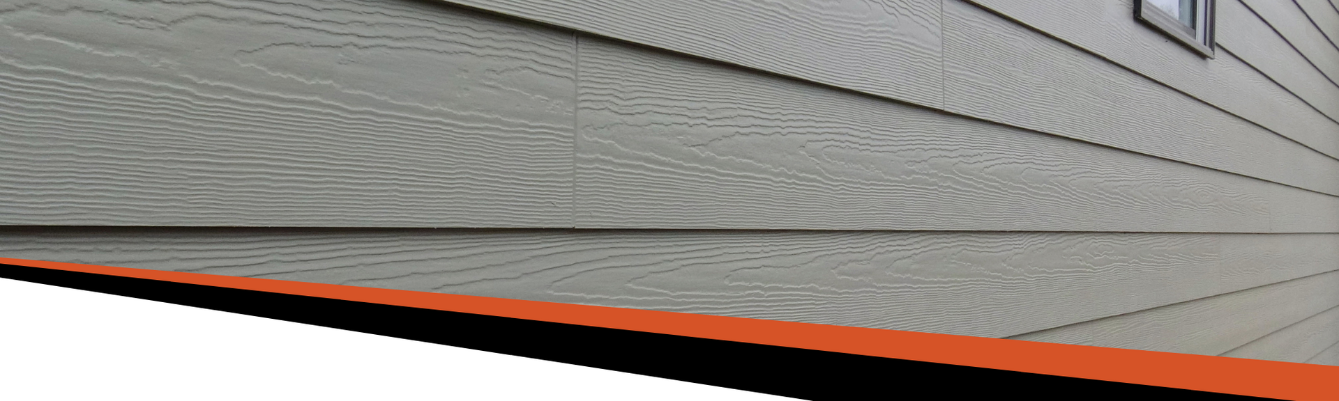Gray siding on a building with an orange trim at the bottom.