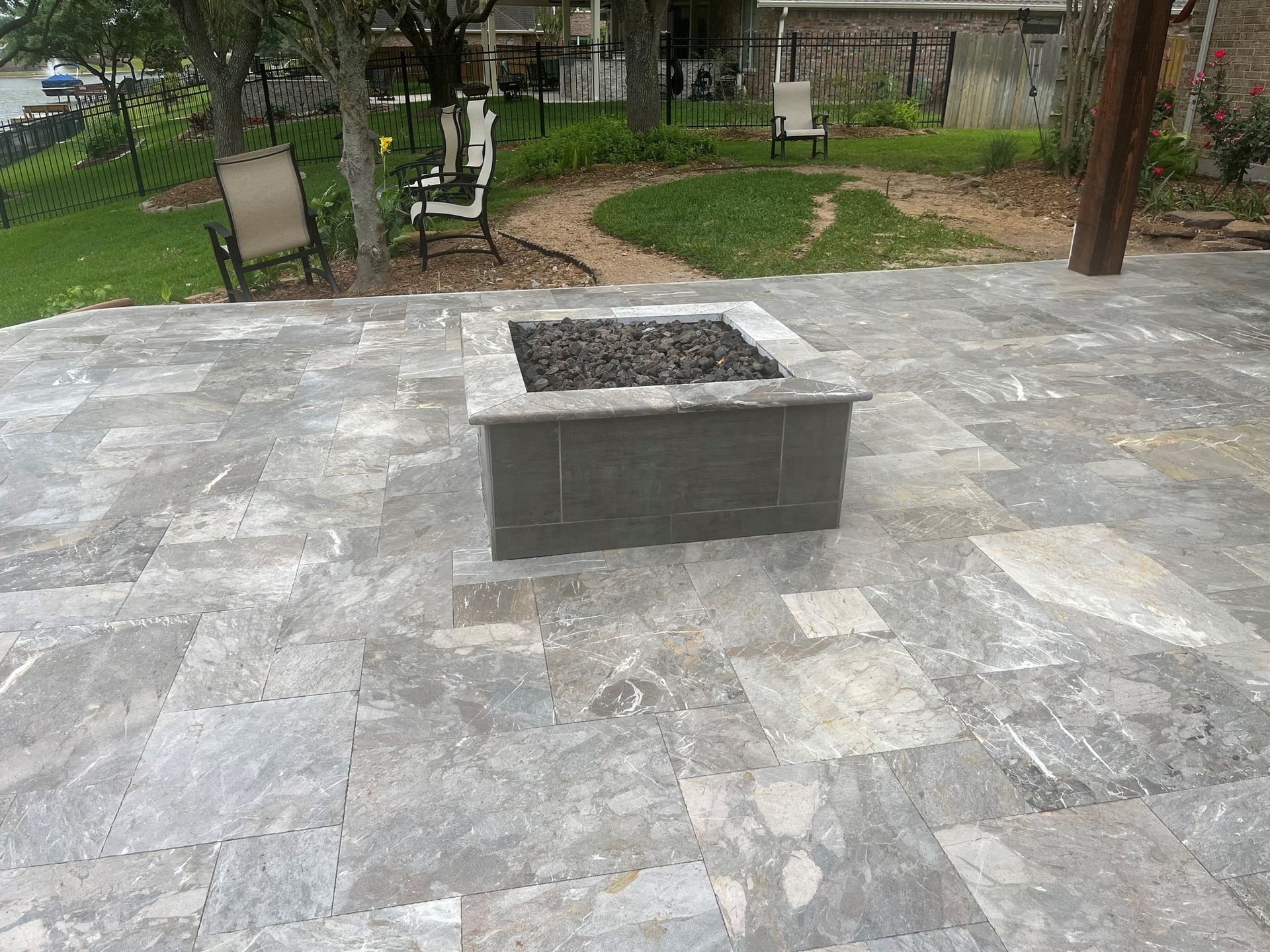 A fire pit is sitting on top of a tiled patio.