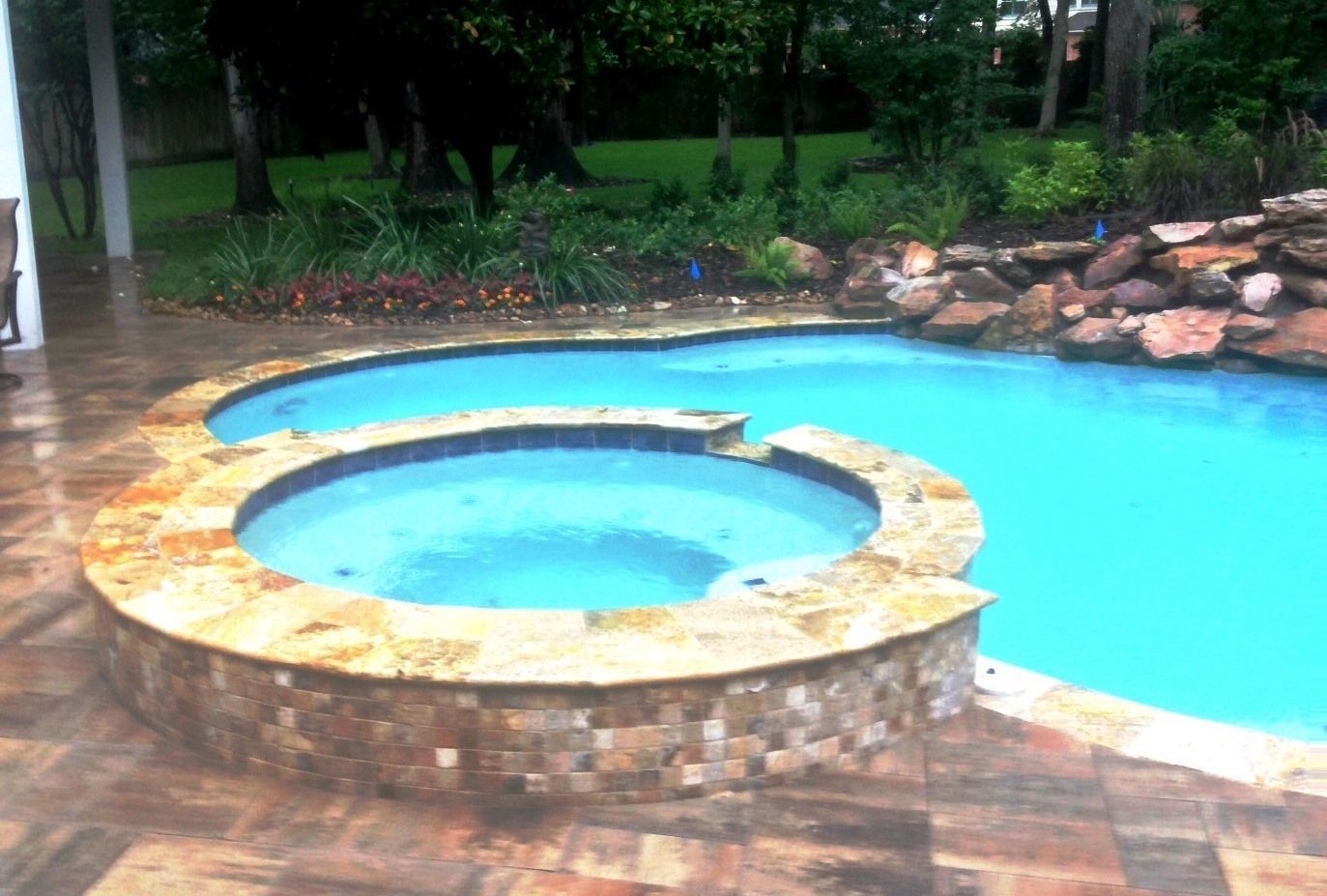 A swimming pool with a hot tub in the middle of it.