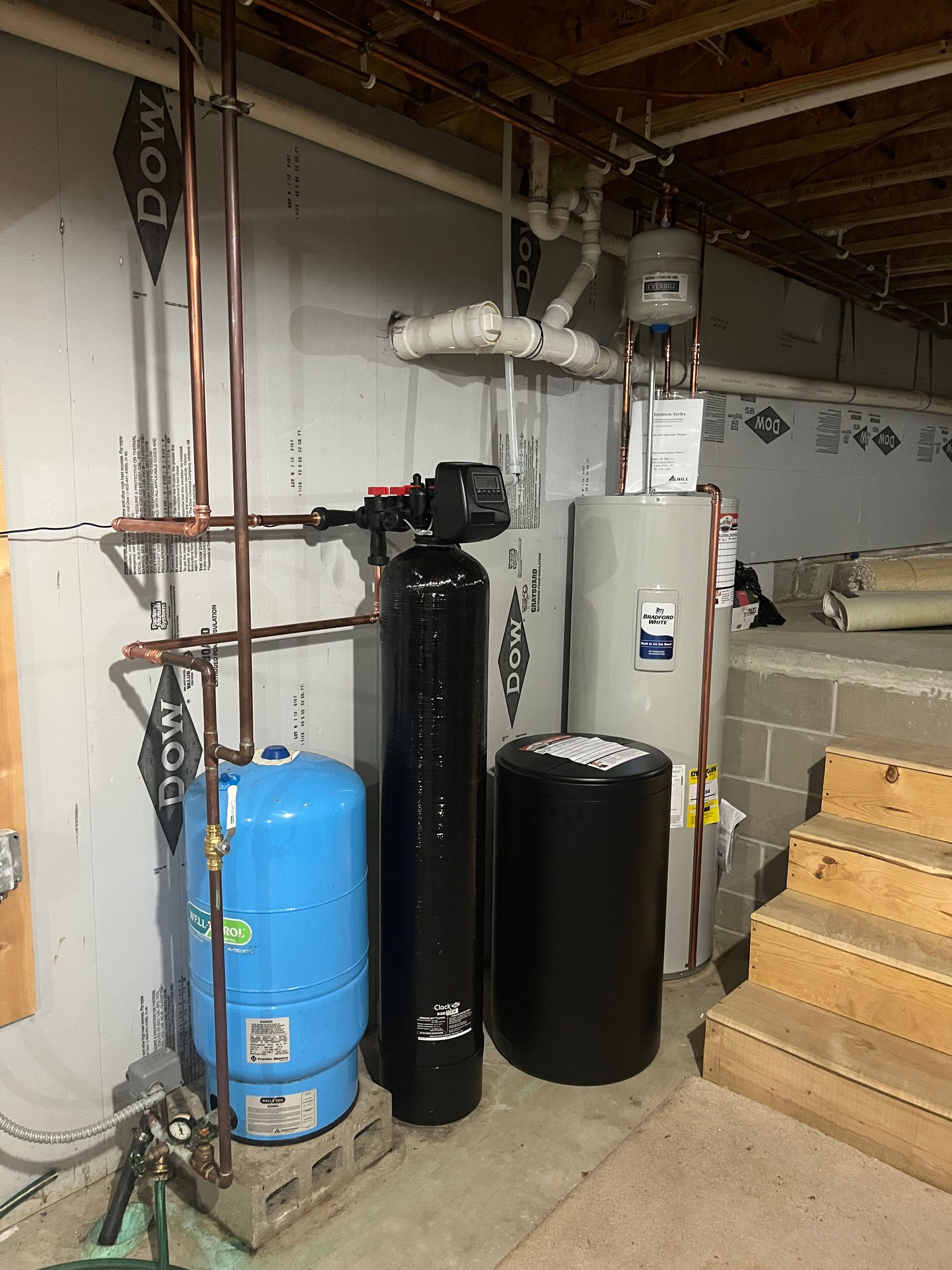 Row of white rooftop air conditioning units against a cloudy sky.
