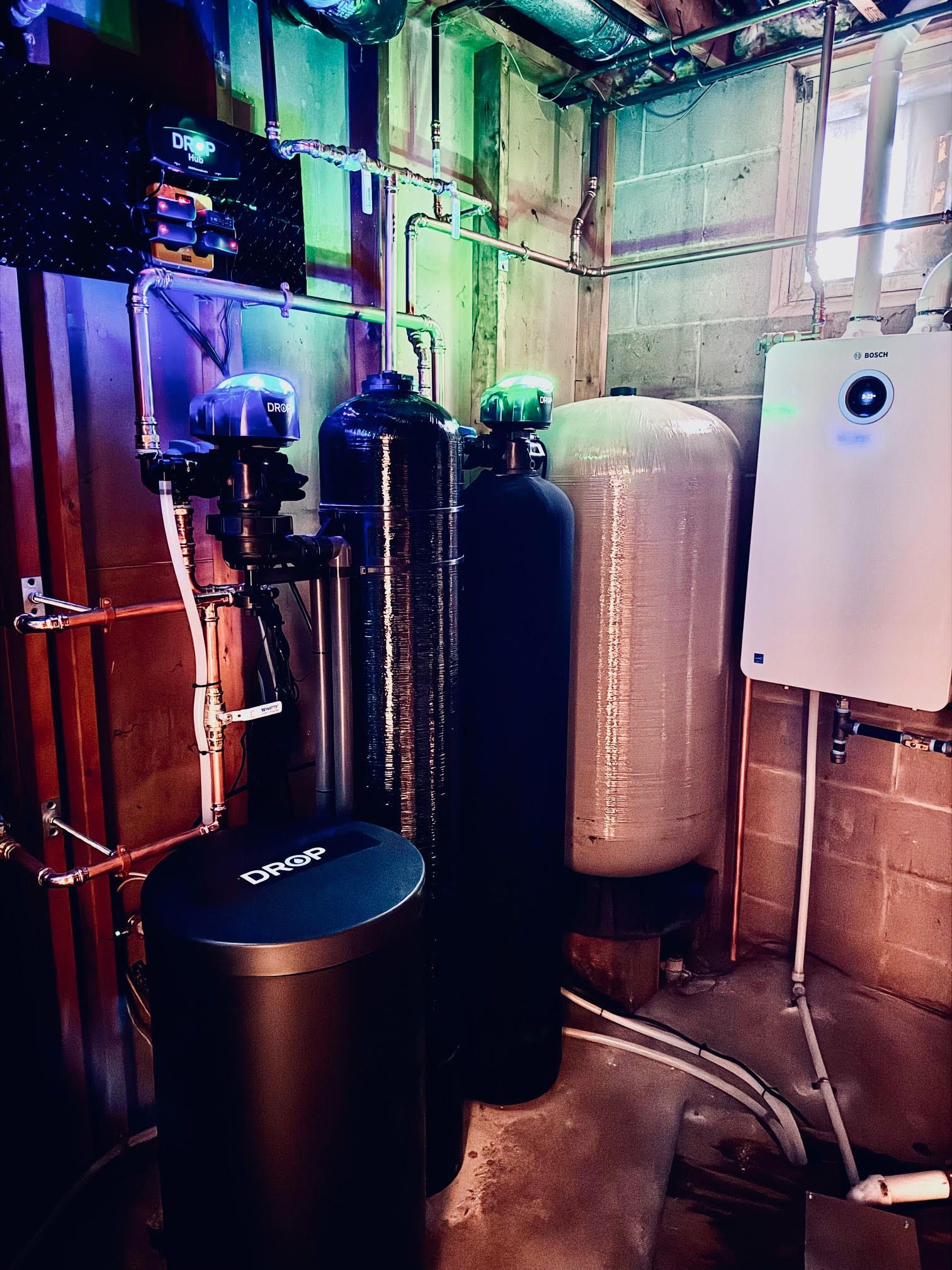 A water filtration system with tanks, a control unit, and remote sensors, against a black background.