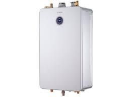 White, wall-mounted, tankless water heater with brass fittings and venting on top.