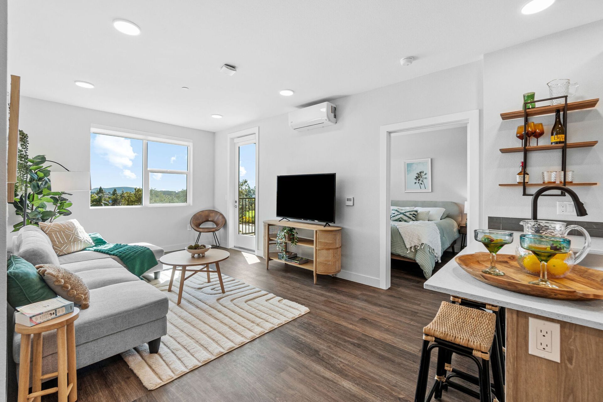 Modern living room with open layout, hardwood floors, and view of the outdoors.