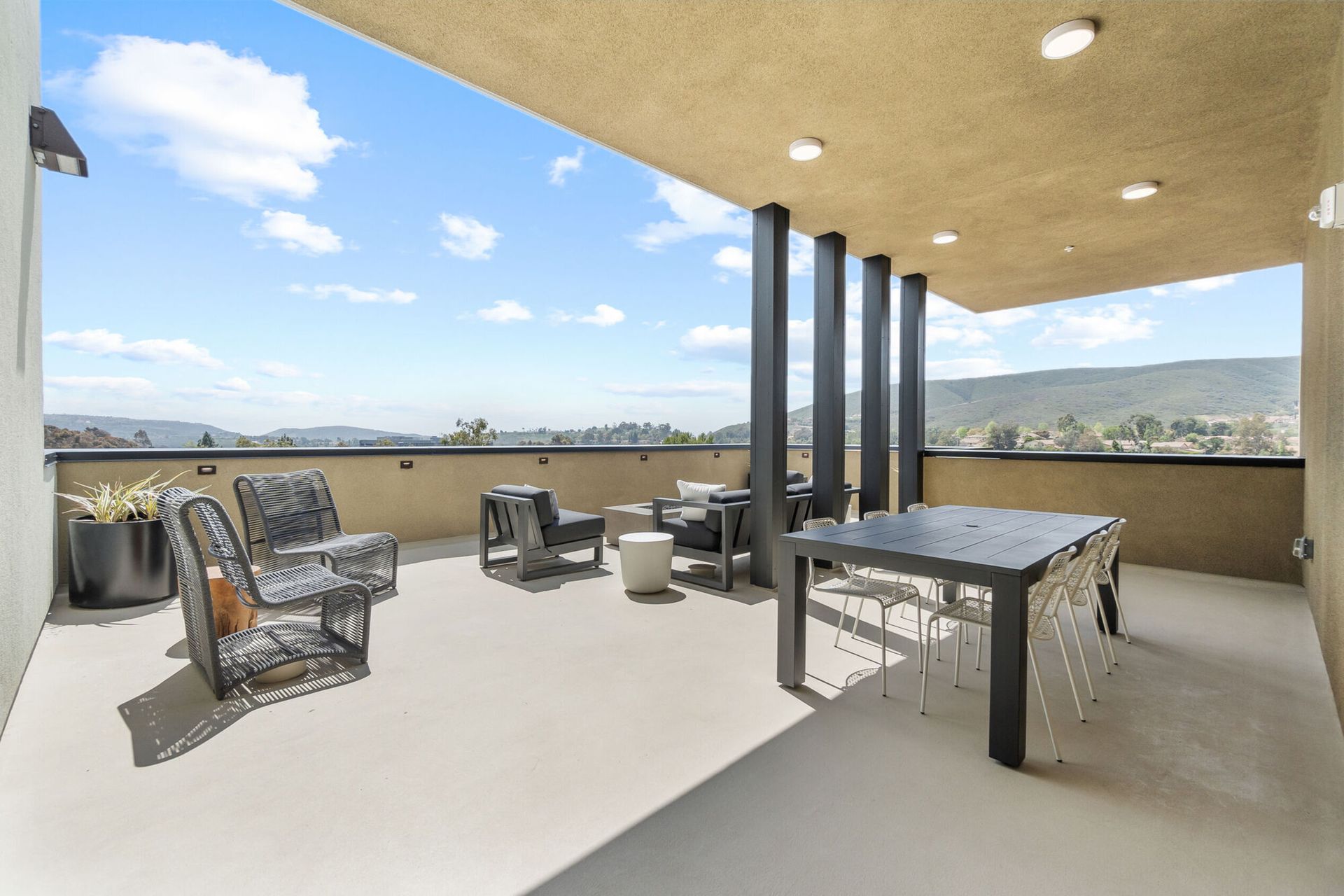Outdoor patio with seating and table, overlooking a valley view.