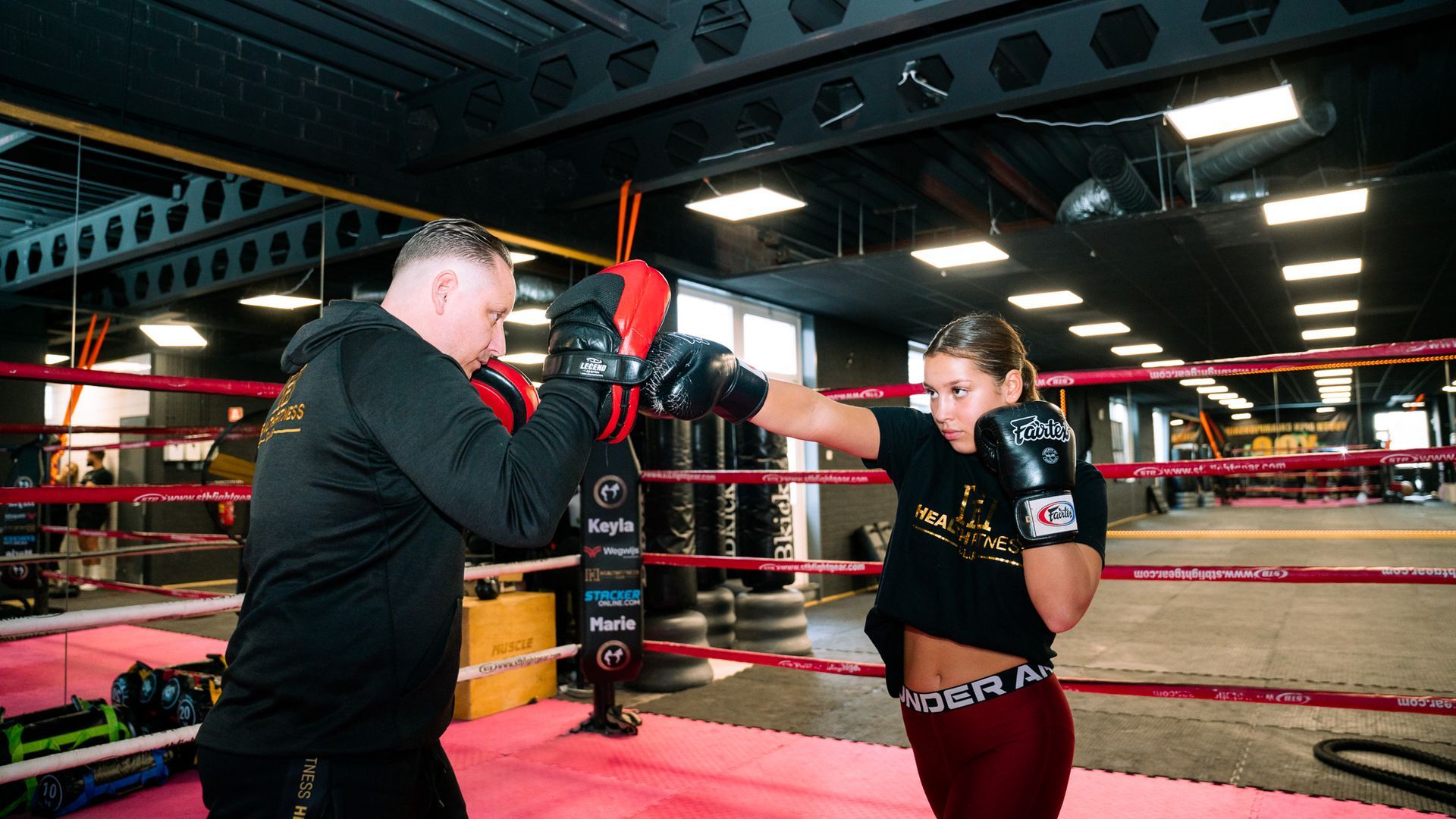 Een man en een vrouw zijn aan het boksen in een boksring.