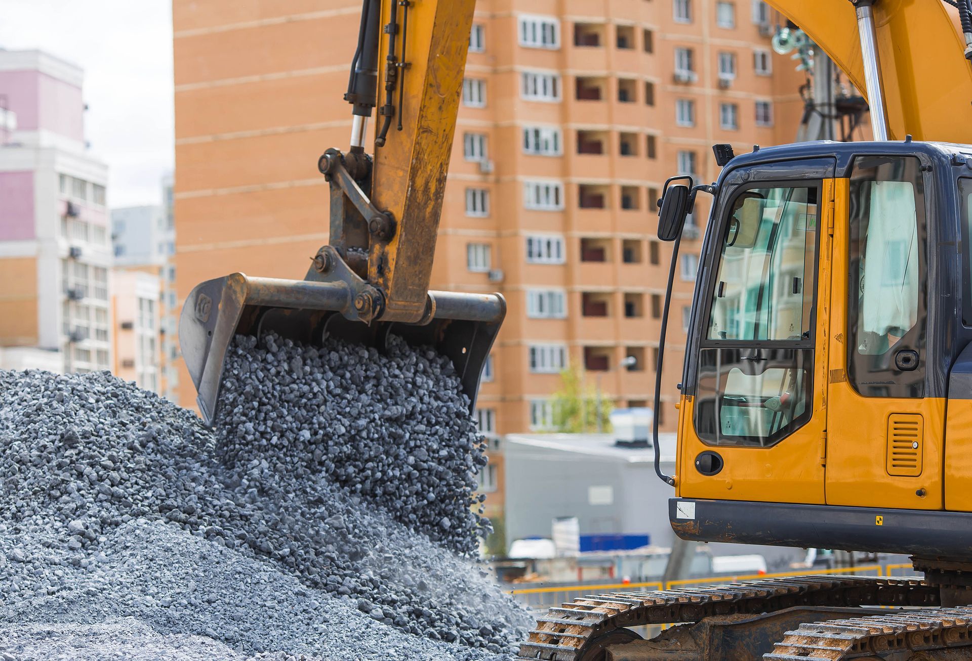 Excavator working on underground pipes. Brown dirt surrounds the black pipes, while the machine is yellow. Excavator working on underground pipes. Brown dirt surrounds the black pipes, while the machine is yellow.