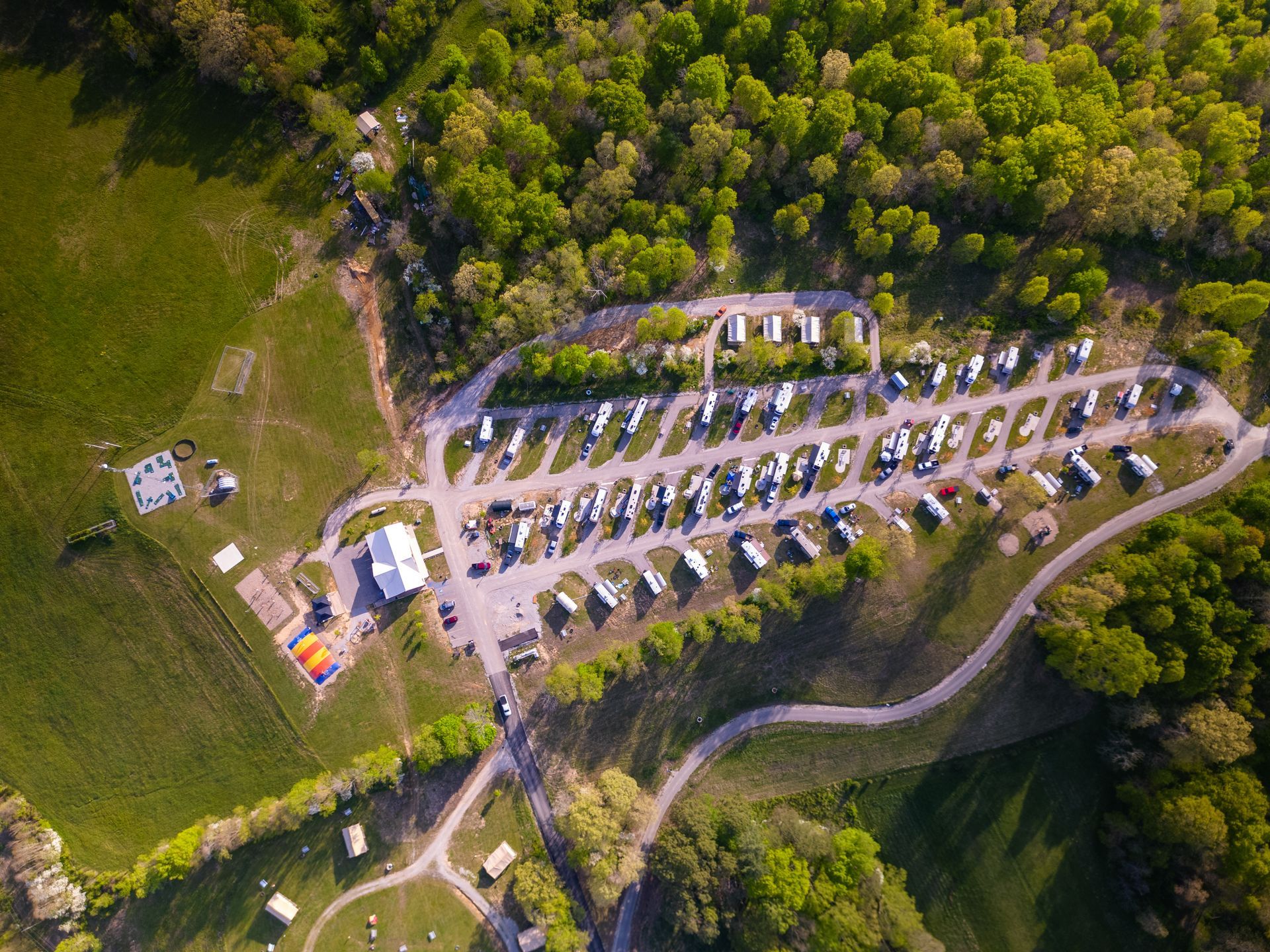 an aerial view of a campground surrounded by trees and grass .