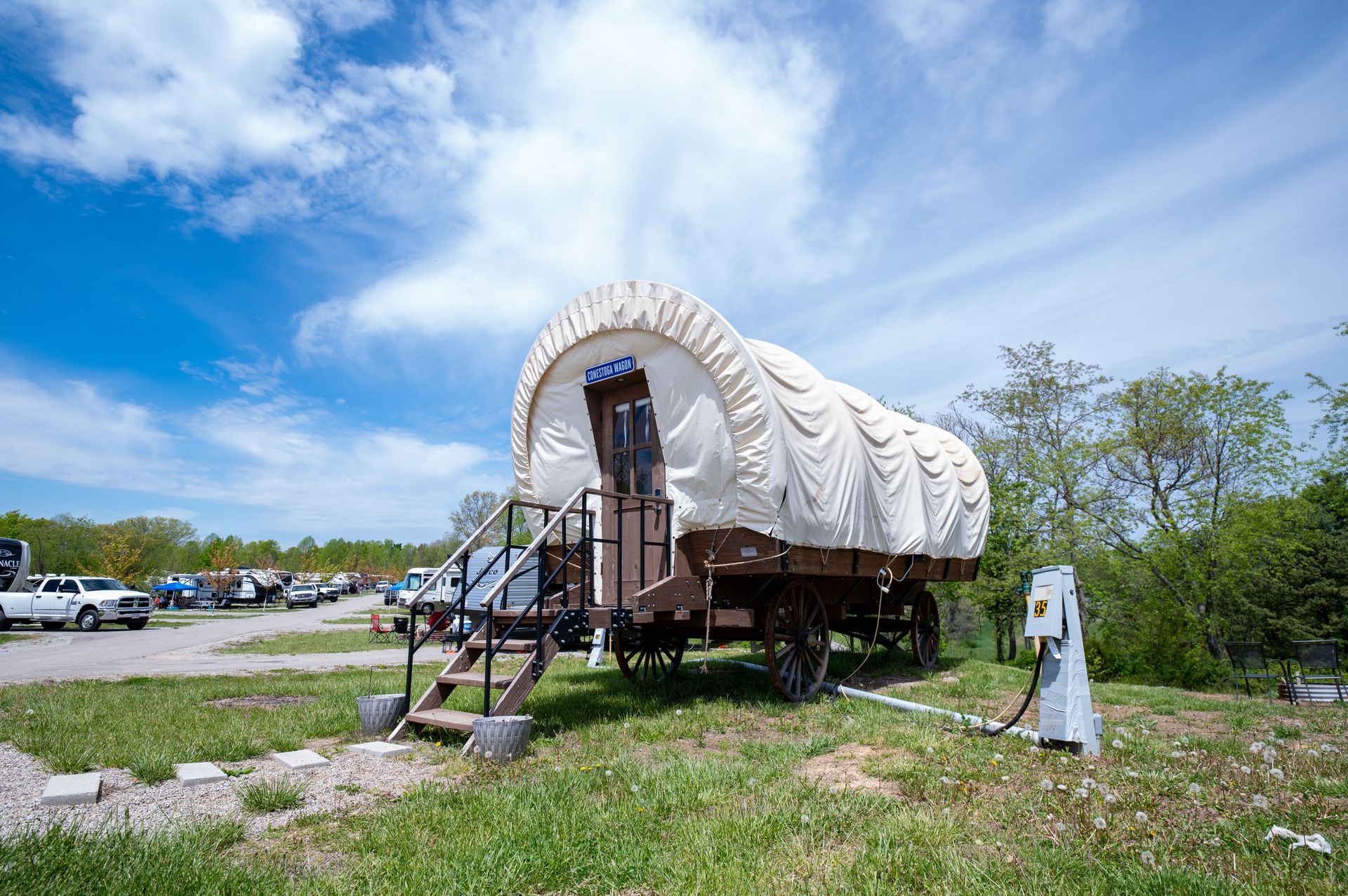 a covered wagon is parked in a grassy field 