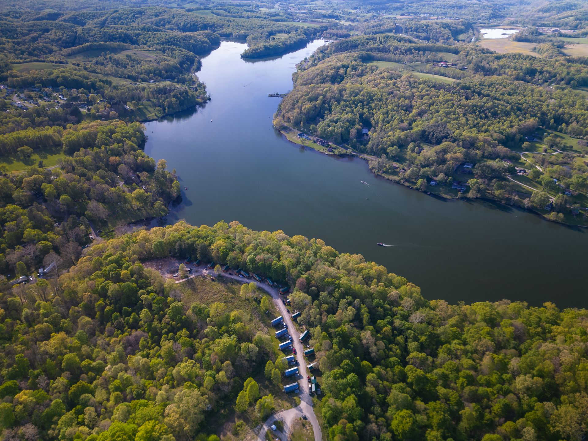 an aerial view of a lake logan surrounded by trees and a campground