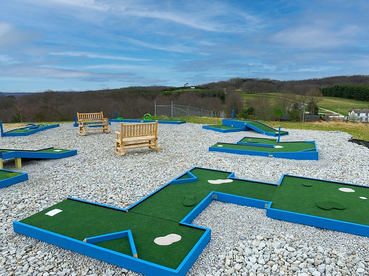 a mini golf course with a bench in the background .