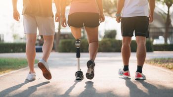 A group of people with prosthetic legs are walking down a path.