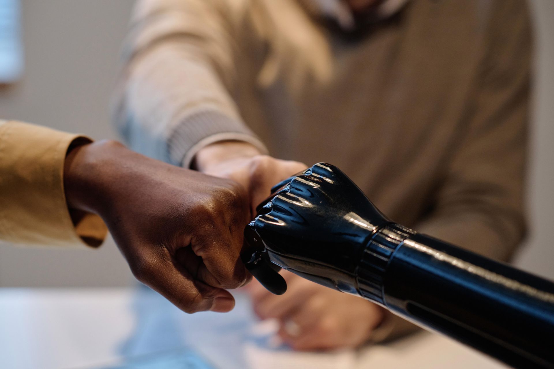 A man with a prosthetic arm is shaking hands with another man.