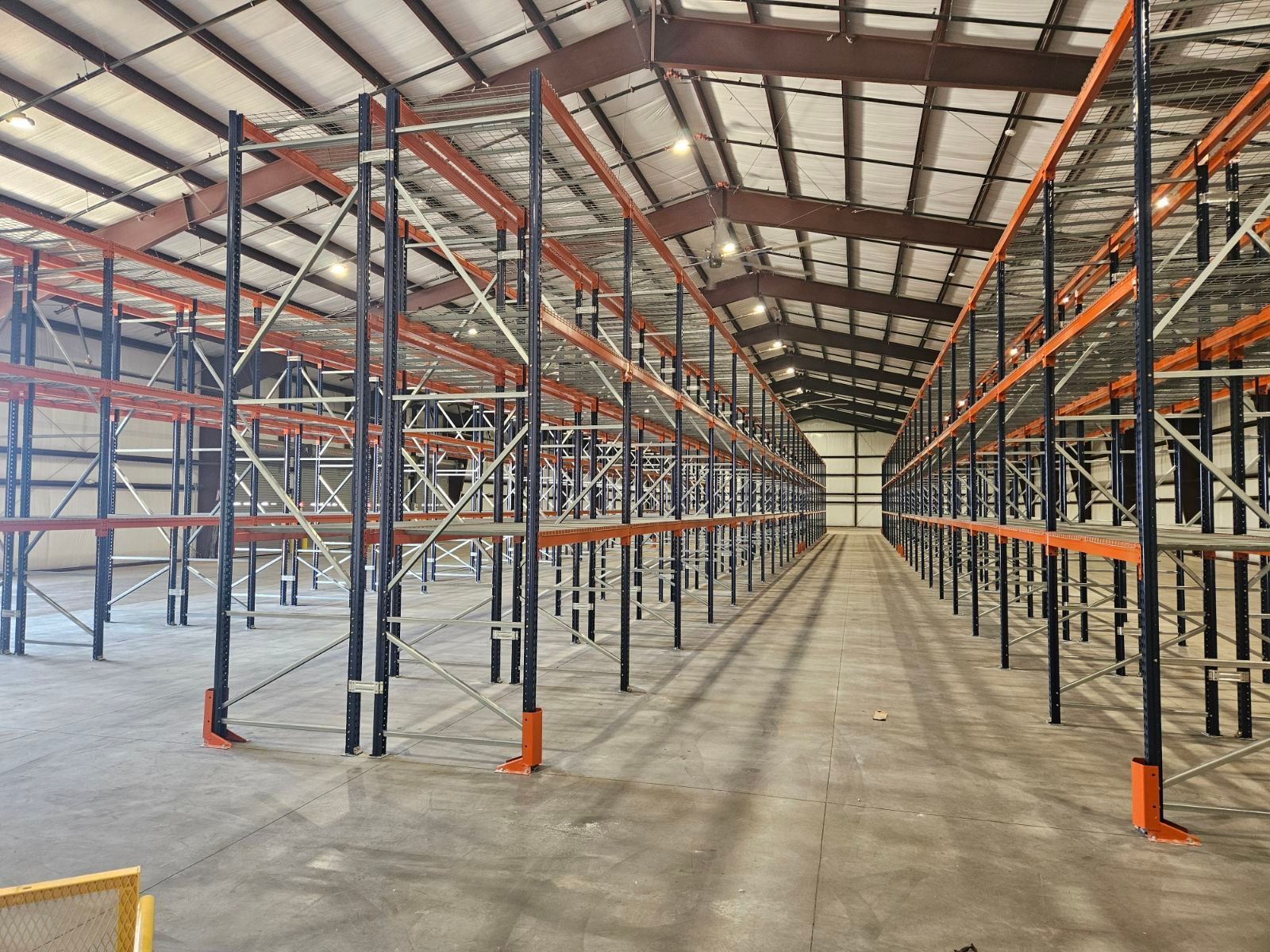 An empty warehouse with lots of shelves and a ladder