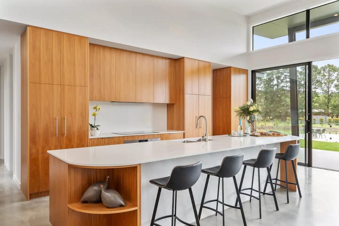 A Kitchen With Wooden Cabinets , A Large Island , and Stools  — That Painter Guy In South Nowra, NSW