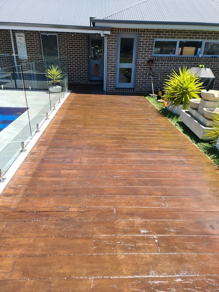 A wooden walkway leading to a house next to a pool