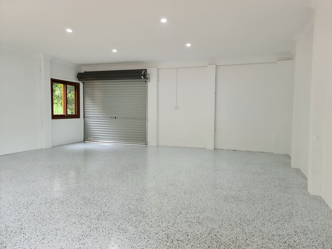 An Empty Garage With A Garage Door And A Window — That Painter Guy In South Nowra, NSW