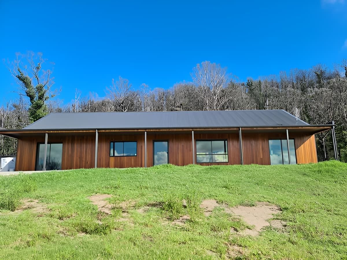 A Large Wooden House Is Sitting On Top Of A Lush Green Hill — That Painter Guy In South Nowra, NSW