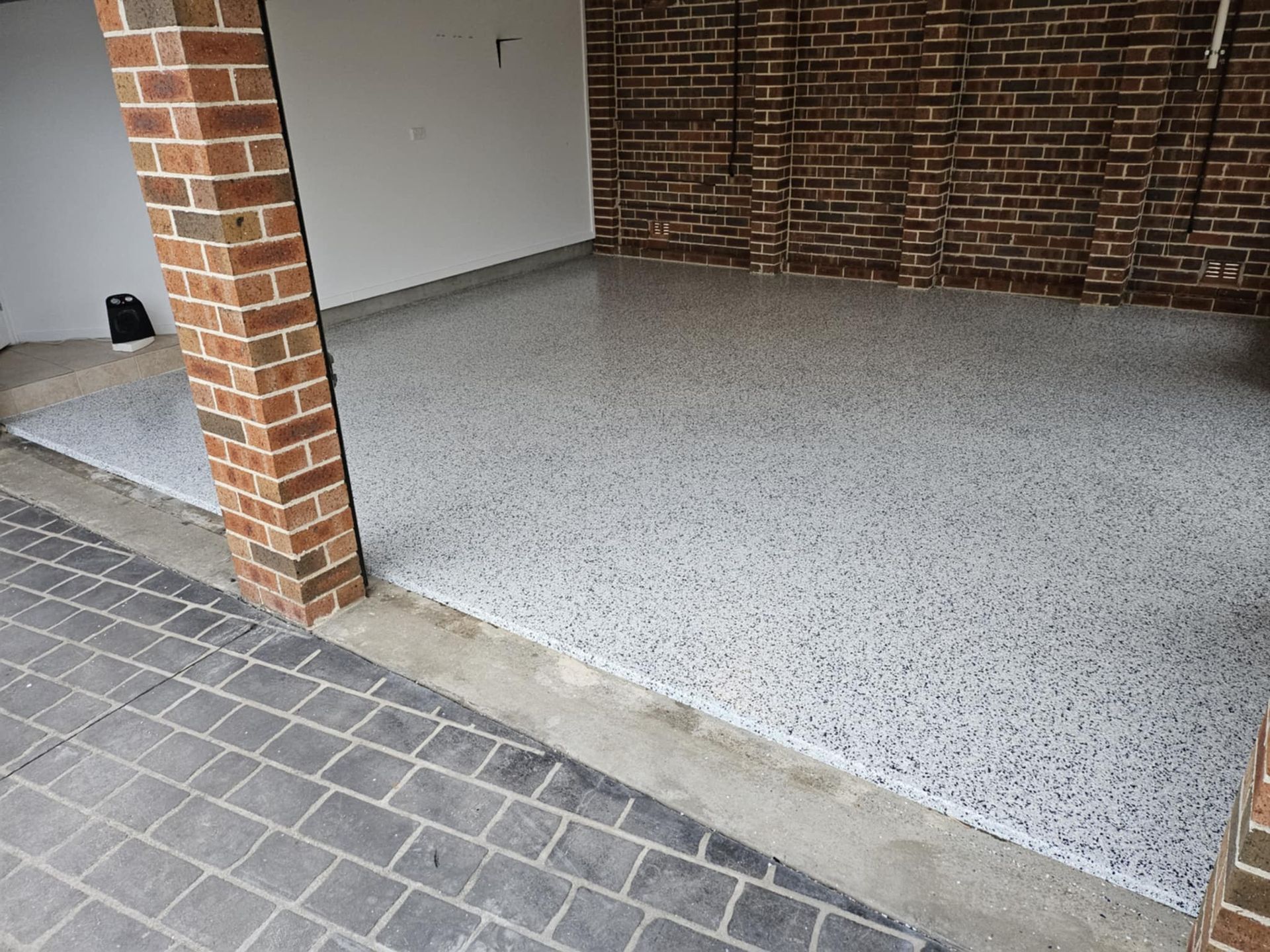 A garage with a brick wall and a concrete floor. — That Painter Guy In South Nowra, NSW