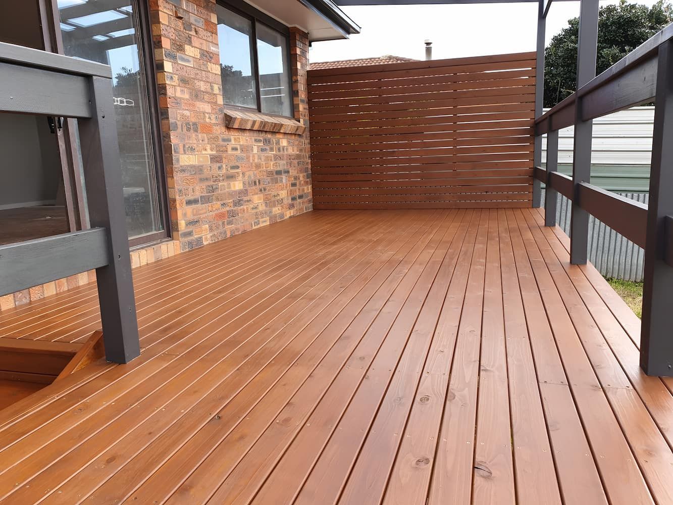 A Wooden Deck With A Railing And A Brick Wall In The Background — That Painter Guy In South Nowra, NSW