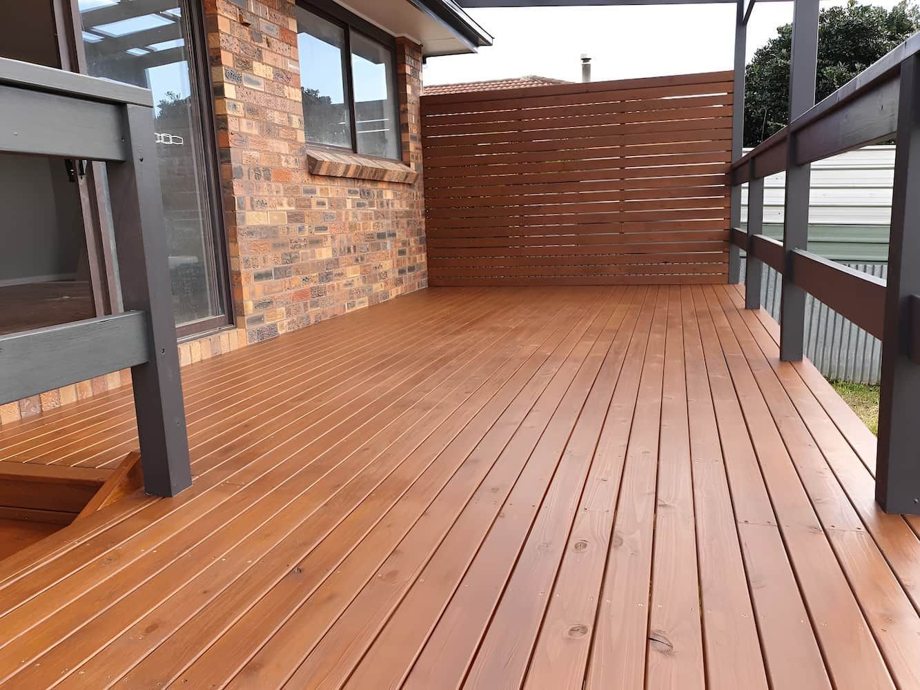 A Wooden Deck With A Brick Building In The Background — That Painter Guy In South Nowra, NSW