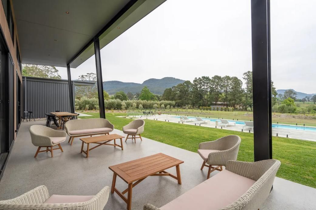 A Patio With A Lot Of Furniture and A Swimming Pool In The Background  — That Painter Guy In South Nowra, NSW