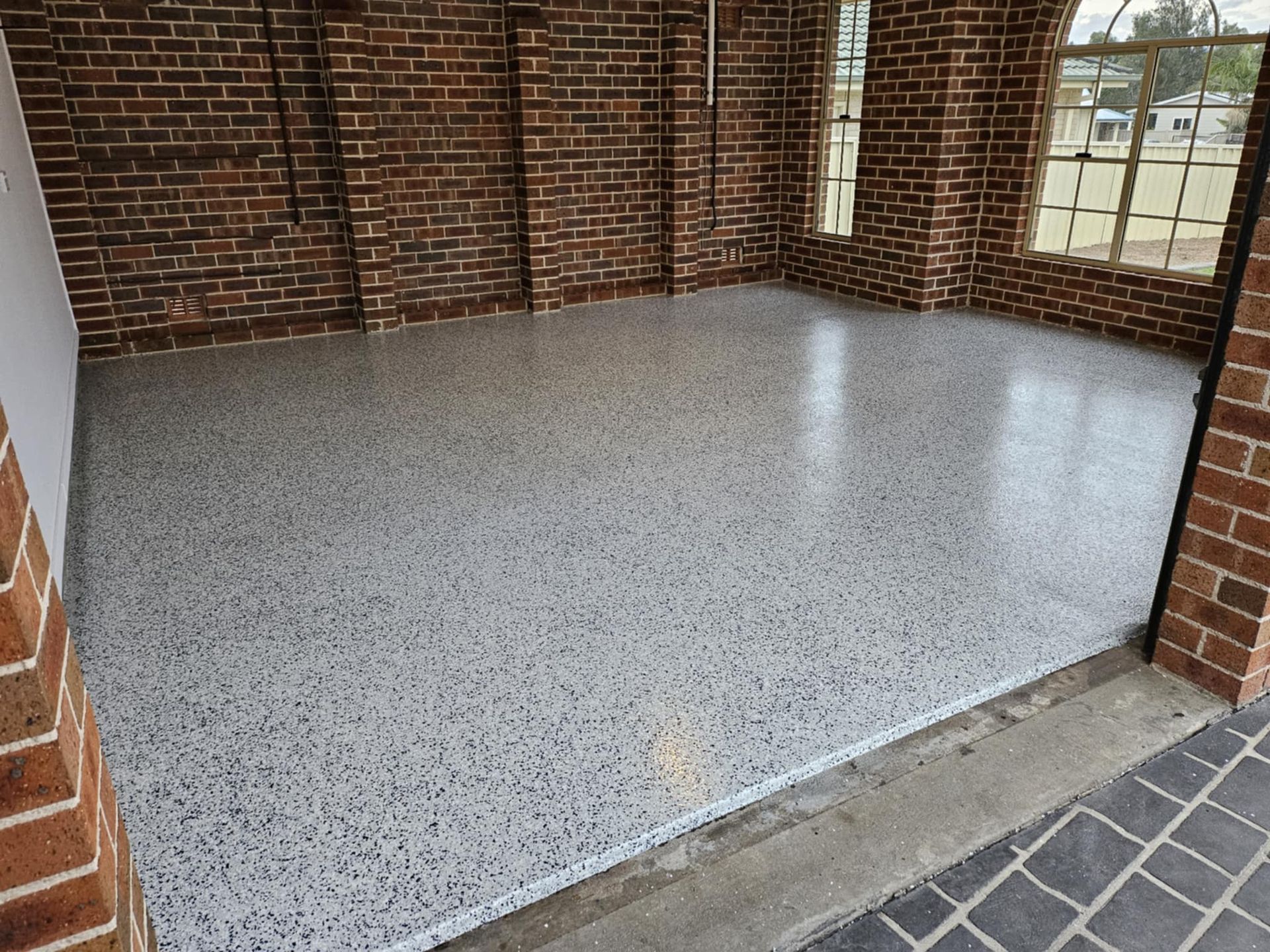 A garage with a brick wall and a white floor.— That Painter Guy In South Nowra, NSW