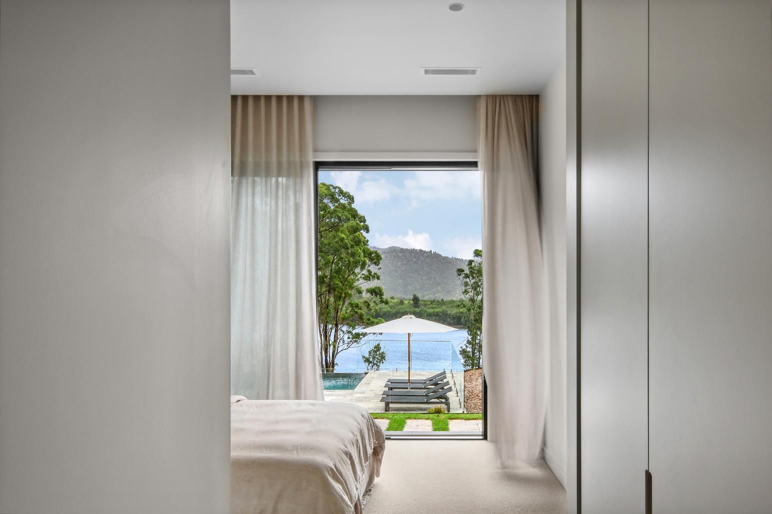 A Bedroom With A Sliding Glass Door Leading To A Pool — That Painter Guy In South Nowra, NSW