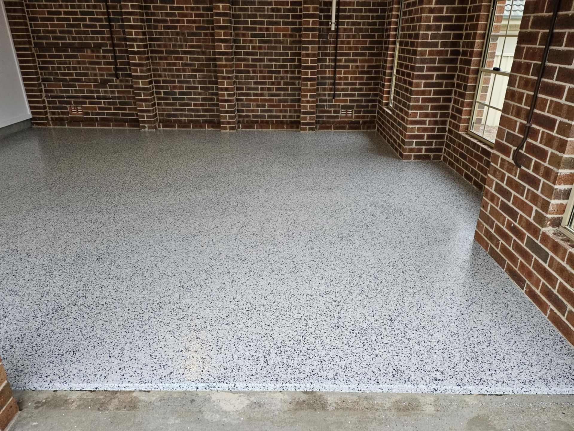 A garage with a brick wall and a white floor — That Painter Guy In South Nowra, NSW