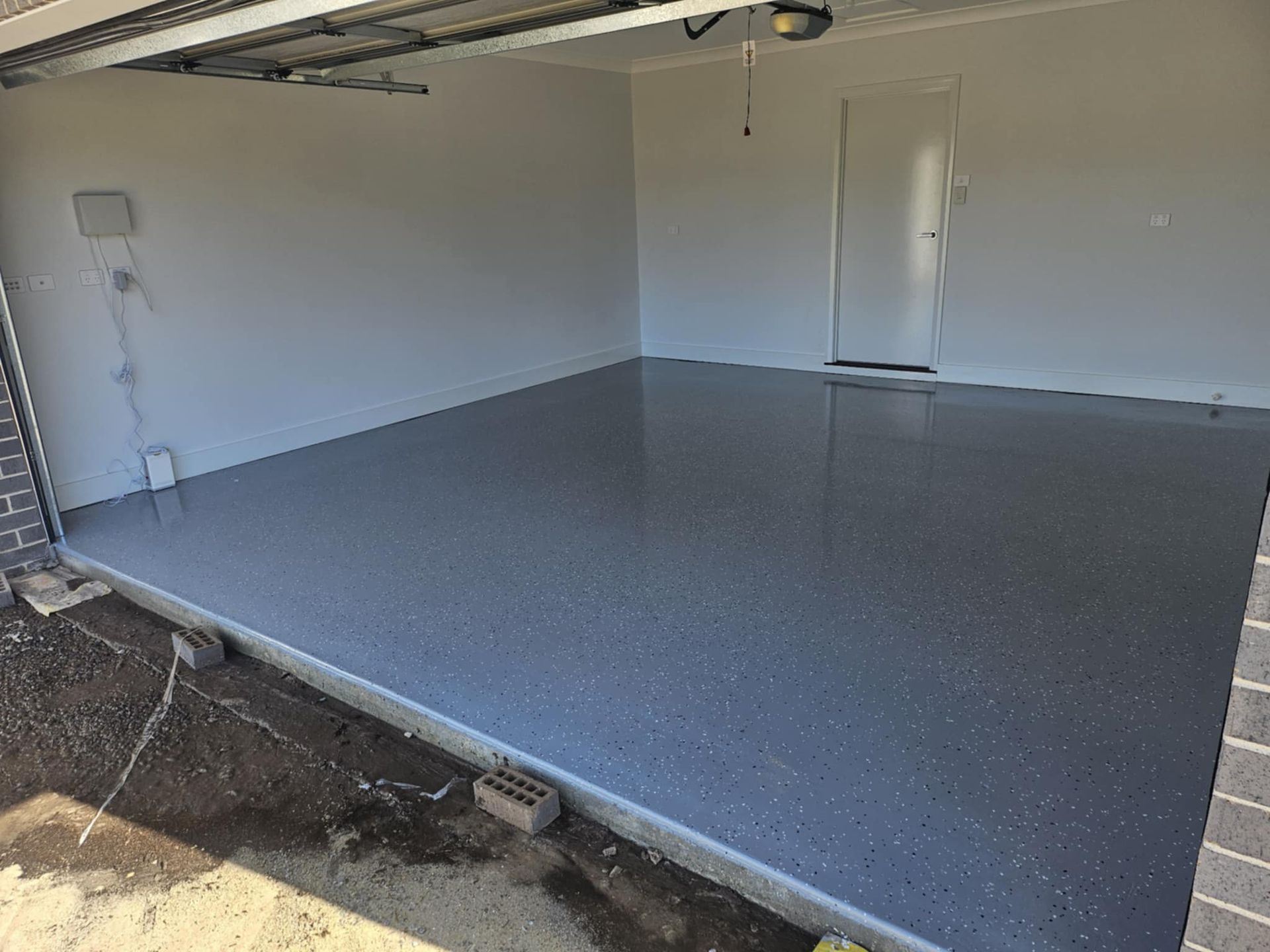 A garage with a concrete floor and a door.— That Painter Guy In South Nowra, NSW