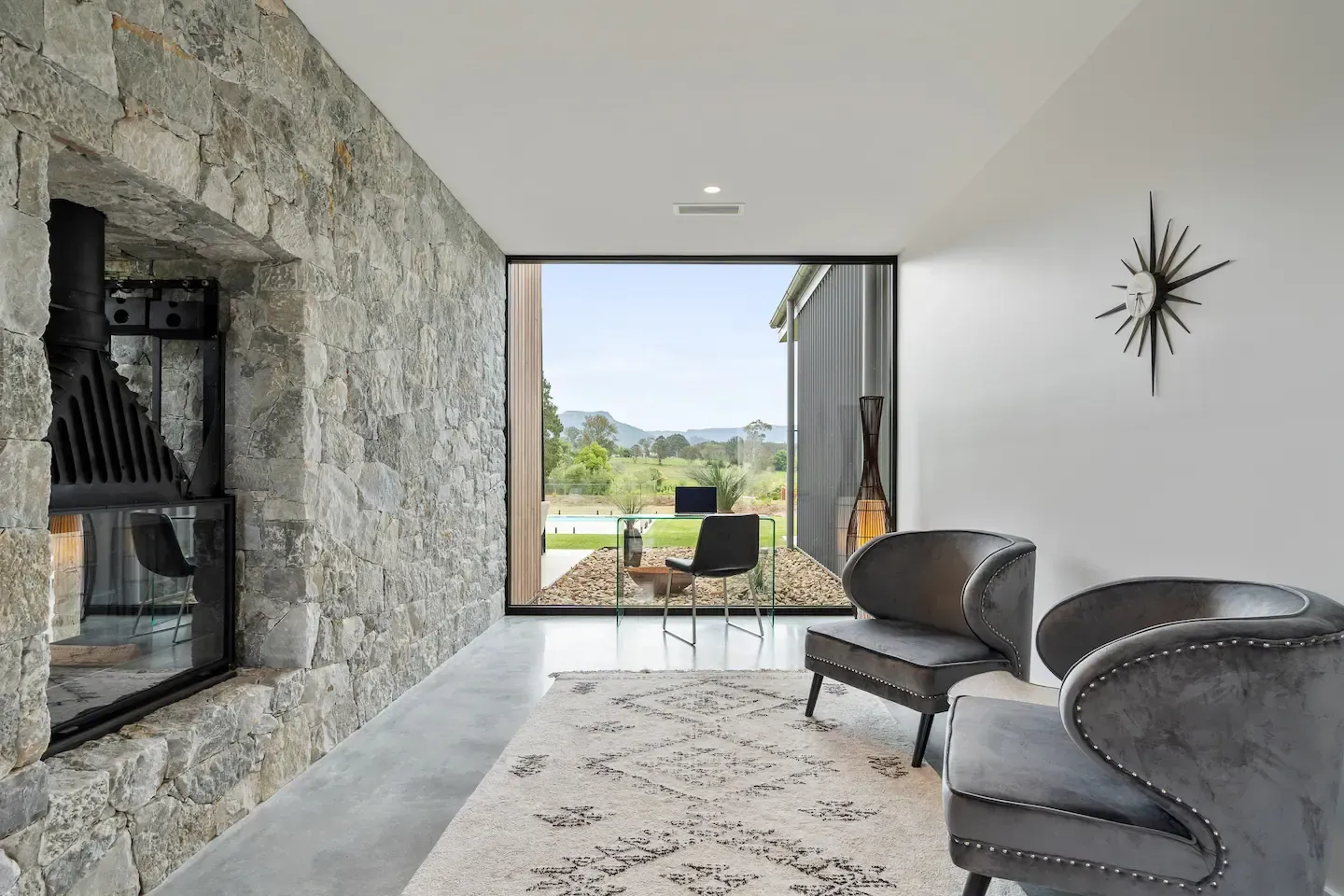 A living room with two chairs , a fireplace and a large window.— That Painter Guy In Vincentia, NSW