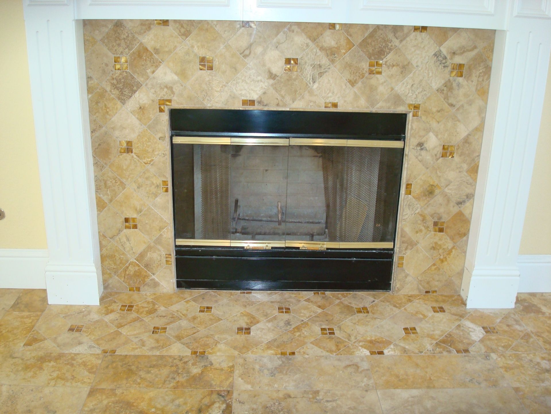 A fireplace with a tiled wall and a black door