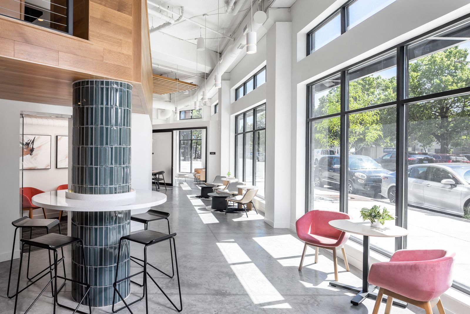 Bright lobby with large windows, seating area, and a blue tiled column