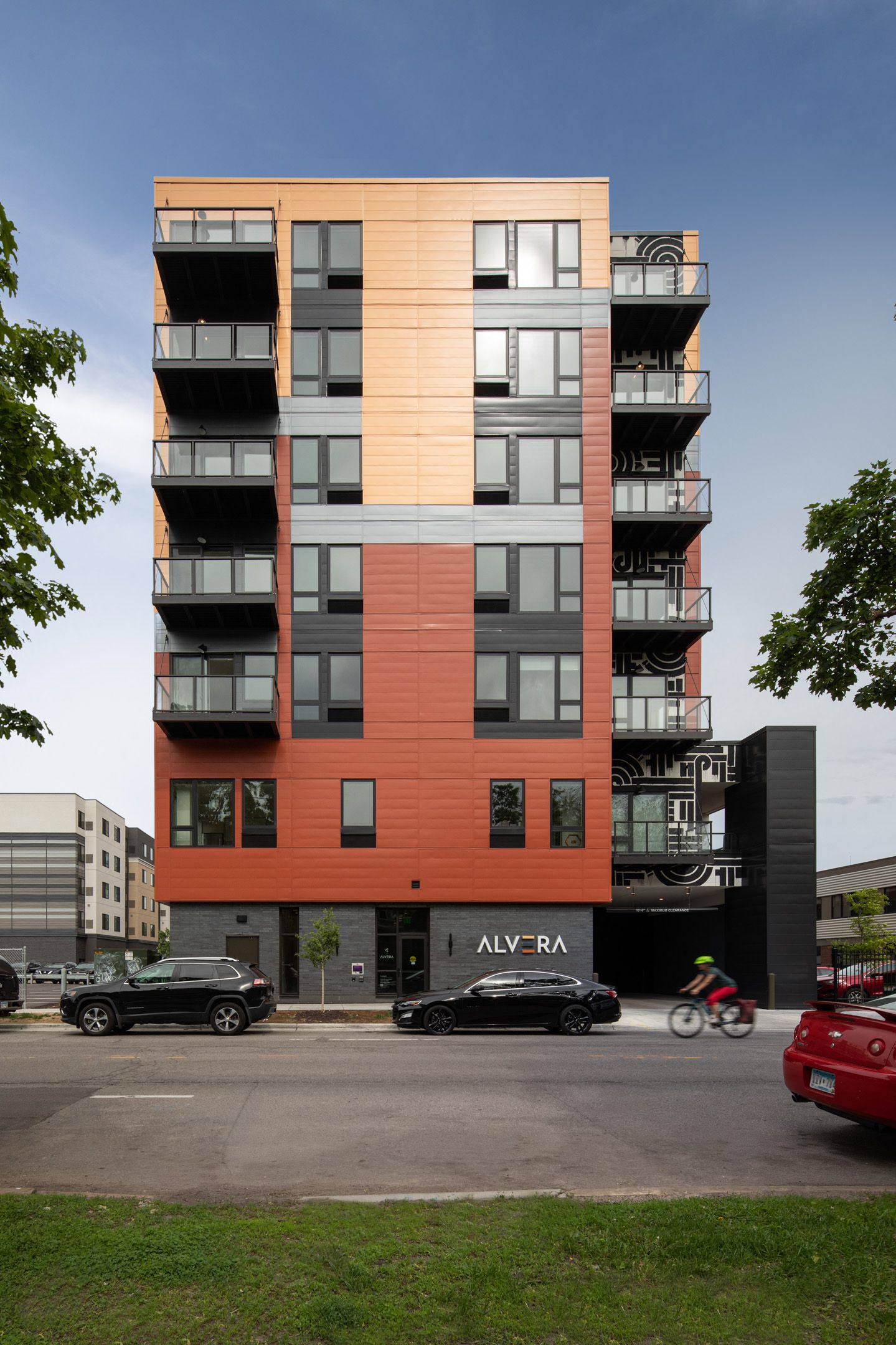 Exterior view of a modern, colorful apartment building with multiple balconies.