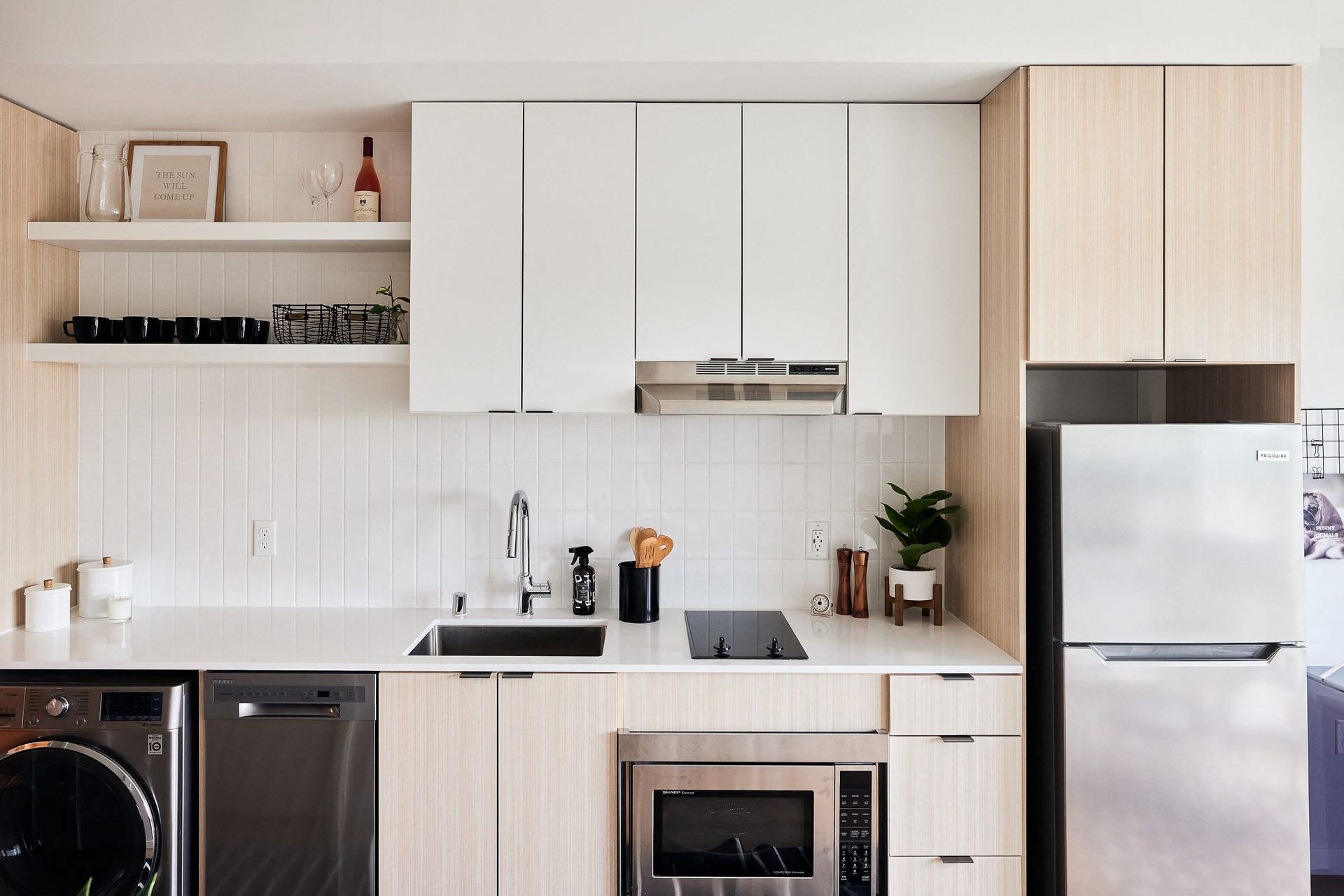 Modern kitchen with white cabinets, stainless steel appliances, and a sink.